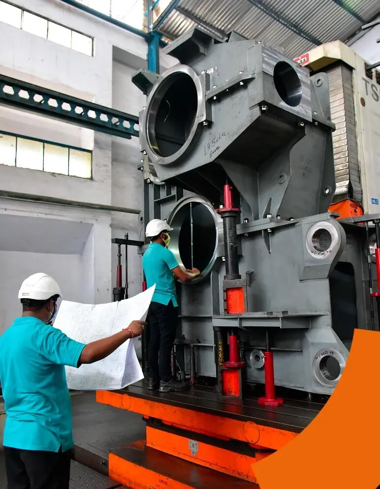 Engineers inspecting a large industrial gearbox housing